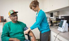 NIH clinical trial participant Curtis Minor has his blood pressure taken by Miriam Baird, R.N.